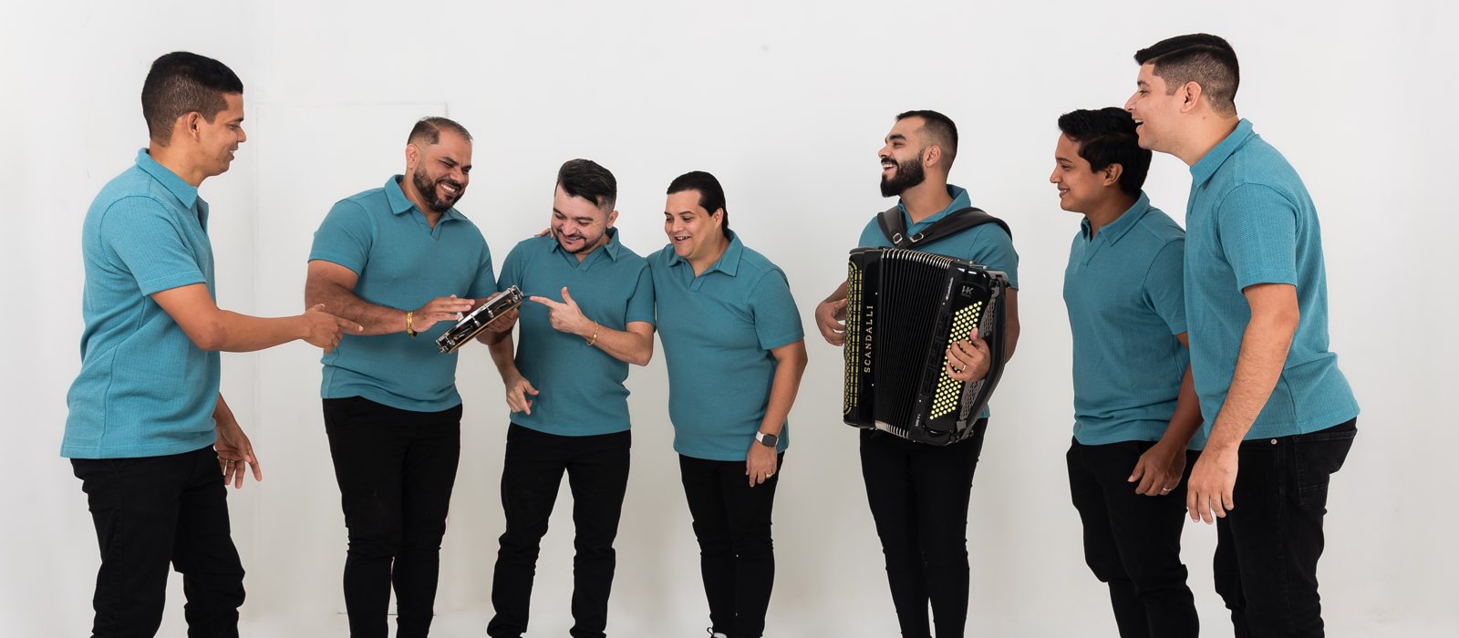 Banda Som e Louvor reunida com o acordeon, de camisas azuis, em clima de celebração